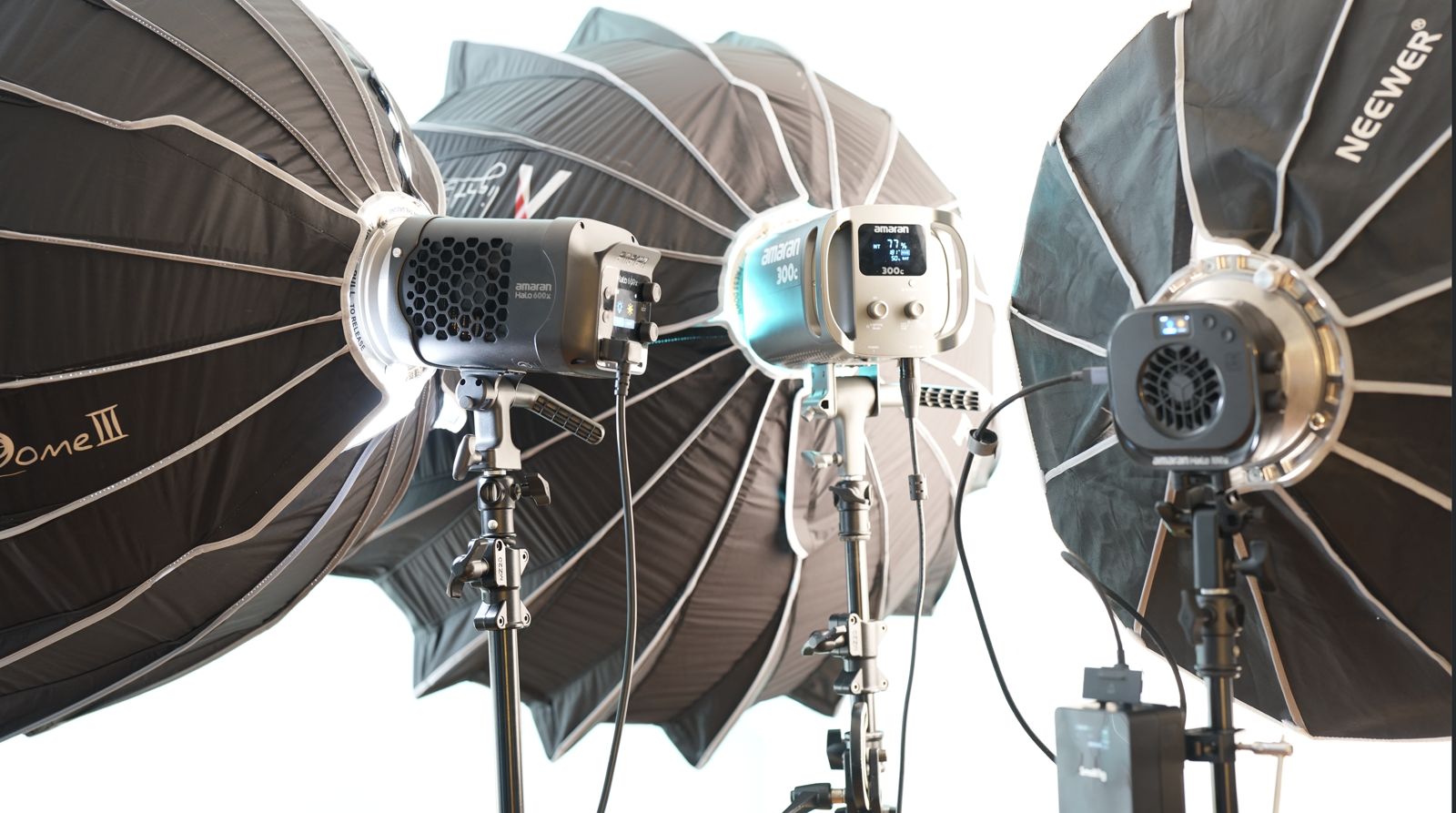 Three parabolic softboxes rigged with Nanlux and Amaran fixtures